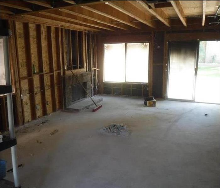 A living room with bare walls down to the studs. 