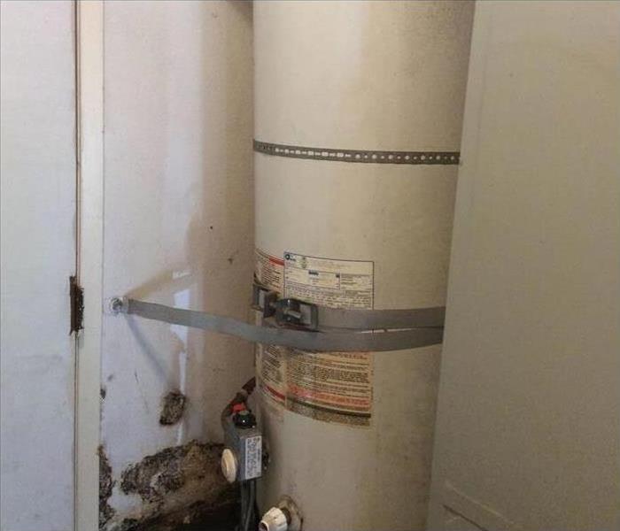 An old, leaky, dirty water heater .