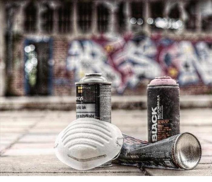 A spray can next to a white mask.