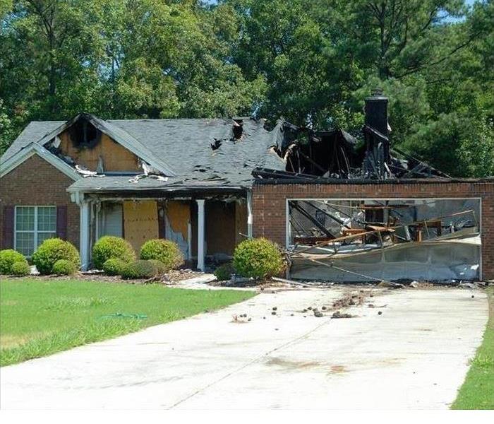 A brown house with a burned roof.